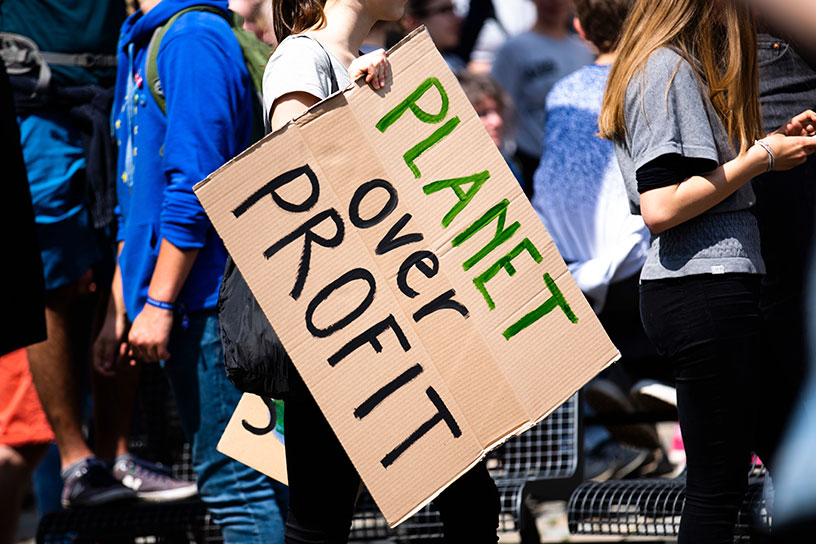 Demonstrations Plakat, auf welchem steht: "Planet over Profit" (Planet vor Profiten)