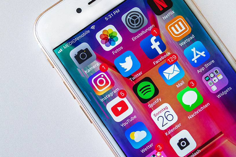 Ein weißes Iphone mit diversen Social Media Apps.